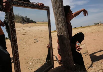 Un manifestante palestino emplea un espejo para desviar la atención de las fuerzas israelíes durante una protesta en la frontera entre Gaza e Israel.