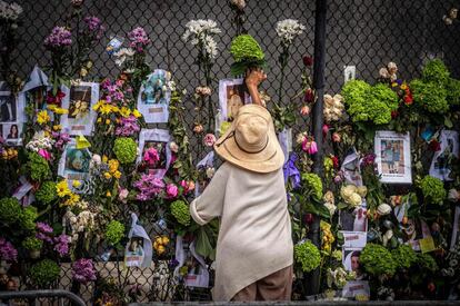 Una mujer deposita flores en el memorial dedicado a las víctimas y los desaparecidos tras el derrumbe de un edificio en Surfside, Florida, EE UU.