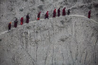 Un grupo de monjes vuelve a su vivienda a pie a través de una empinada colina tras asistir a una sesión de cantos durante la mayor Asamblea Dharma Bliss que se celebró el 30 de octubre de 2015.