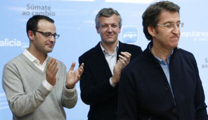 El responsable de Organización, Alejandro Gómez, y el secretario general del partido, Alfonso Rueda, aplauden ayer a Feijóo en la sede del PP en Santiago.