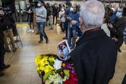 Un vecino sostiene una foto de Díaz Ayuso durante el acto en el metro madrileño con la presidenta de la Comunidad y candidata a la reelección.
