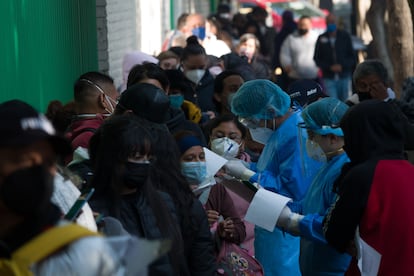 Decenas de personas se hacen esperan para realizarse una prueba de antígenos para detectar covid-19.