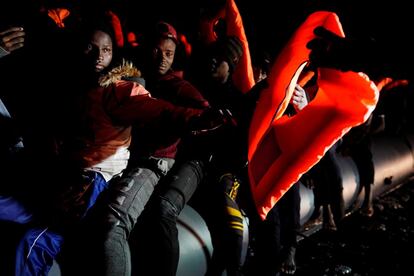 Migrantes reciben chalecos salvavidas durante una operación de búsqueda y rescate (SAR) realizada por la ONG Proactiva Open Arms en el mar Mediterráneo central.