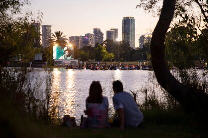 Una pareja observa el cine que se proyecta en botes flotantes en Tel Aviv.