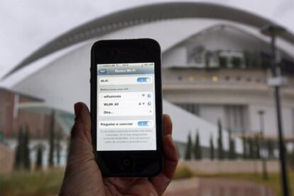 Un usuario capta una red wifi en el Jardín del Turia, junto al Palau de les Arts.