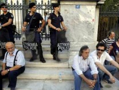 Varios empleados de la radiotelevisión pública griega ERT sentados en las escaleras del Consejo de Estado, durante una protesta, en Atenas. EFE/Archivo