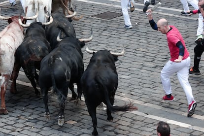 Un mozo corre junto a los astados de la ganadería de Jandilla a su paso por la plaza del Ayuntamiento, durante el sexto encierro de los Sanfermines.