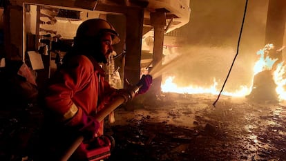 Un miembro de la Defensa Civil Palestina lucha contra las llamas tras los ataques israelíes sobre la ciudad de Rafah, al sur de la franja de Gaza, este lunes. 