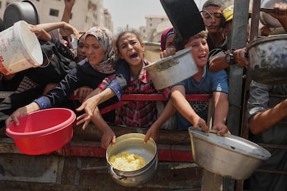 Varios palestinos esperan para recibir comida en una cocina comunitaria en Gaza, el pasado 16 de agosto.