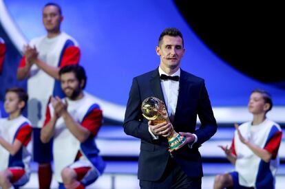 O ex-jogador alemão Miroslav Klose leva ao palco do Palácio do Kremlin, em Moscou, a taça da Copa do Mundo 2014. 