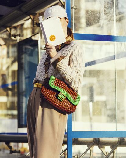 Gorra beis de algodón de Deus Ex Machina, camisa de seda arrugada de Rochas, jersey de punto de ochos de Uniqlo, pantalón de pinzas de Zara, cinturón de piel de color amarillo de Gerard Darel, bolso de piel trenzado bicolor de Fendi, pulsera rígida de Emporio Armani, gafas de carey de Hugo Boss y pendiente pequeño dorado con brillantes de Apodemia.