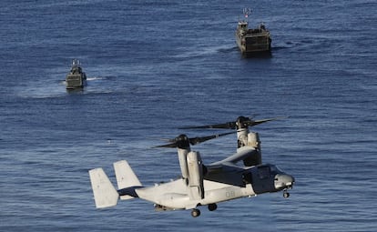 Vista de un helicóptero de combate y dos embarcaciones durante las maniobras.