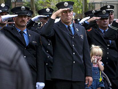 Un grupo de bomberos de Nueva York, ayer, saluda a su paso a la familia de Peter Bielfeld, un compañero fallecido el 11-S, durante su funeral. PLANO MEDIO - ESCENA