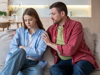 Offended woman sitting on sofa, unwilling to communicate with husband. Reserved wife, keeping silence because of emotional pain, offence, disappointment. Caring man calming down irritated angry female