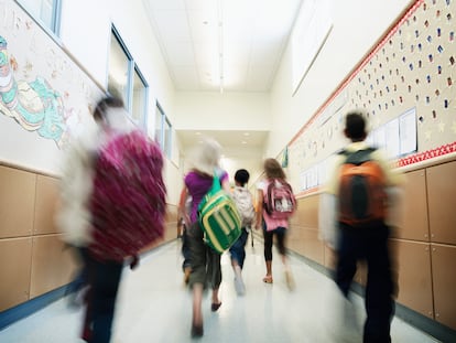 Alumnos de una primaria caminan por el pasillo.