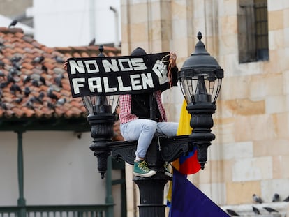 Un hombre con un cartel dirigido al nuevo Gobierno, durante la posesión el pasado 7 de agosto en la Plaza de Bolívar.