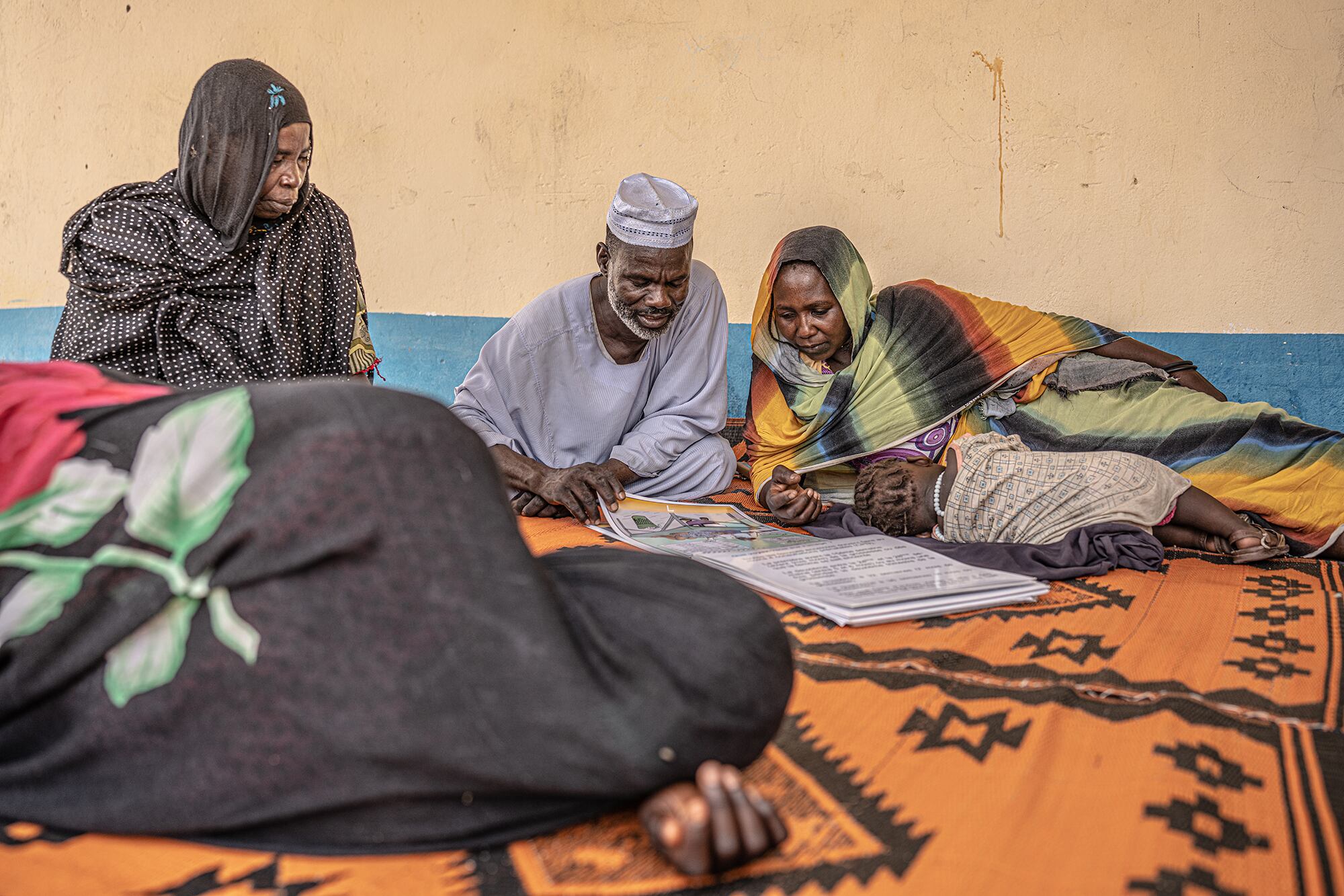 Bilal Isa y Fatima Arab Adam leen los manuales sobre planificación familiar, en una sesión de sensibilización sobre matrimonio precoz en el centro de salud de la comunidad de Barata, en Chad. 