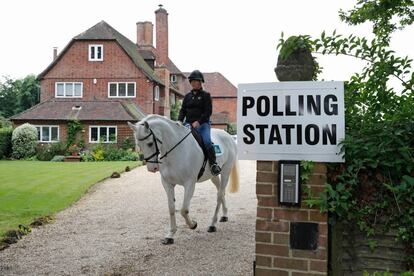 Sophie Allison, montanda en su caballo Splash, abandona una vivienda que se utiliza como centro electoral, cerca de Reading (Inglaterra).