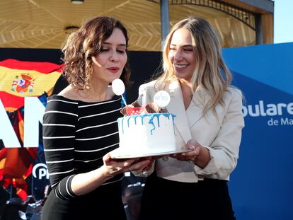La presidenta de la Comunidad de Madrid, Isabel Diaz Ayuso, sopla las velas de una tarta junto a la diputada Noelia Núñez para celebrar el aniversario de las elecciones del 4-M.