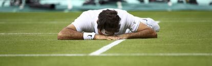 Federer, tendido sobre el c&eacute;sped de la pista central de Wimbledon.