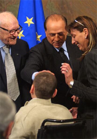 Silvio Berlusconi saluda a un niño en el palacio Chigi de Roma.