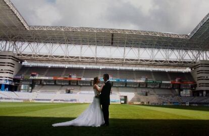 Amelia Sánchez y Héctor Martínez, abonados del Oviedo, posan en el Carlos Tartiere para sus fotos de boda.