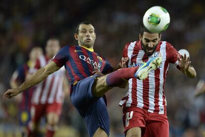 Mascherano intenta arrebatarle el balón a Arda.