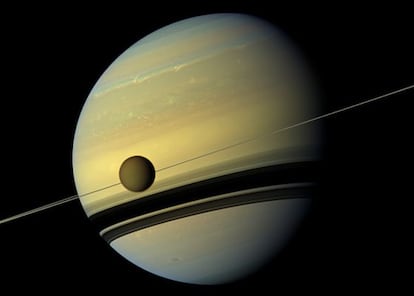 El planeta Saturno y su luna Titán, cruzándose por delante, fotografiados por la sonda espacial 'Cassini'.