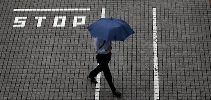 Un hombre pasea por los aleda&ntilde;os de la Bolsa de Tokio