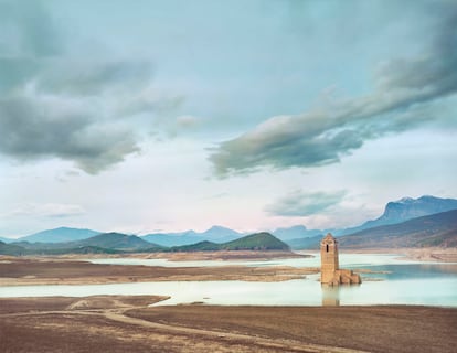 Pantano de Mediano (Huesca). A Manso lo han descrito como “el fotógrafo más paciente del mundo”, apelativo que cobra sentido cuando se conoce cómo se hizo esta imagen del embalse de Mediano. Acudió al mismo lugar en diferentes días y momentos. Una mañana de lluvia cerrada intuyó que, si escampaba a tiempo, la luz podría ser mágica —un adjetivo que repite mucho—. En el pantano, esperó a pie quieto durante horas, en un terreno fangoso, calzado con unas botas altas de goma, bajo un paraguas, solo y cargando un equipo enormemente pesado —las placas de gran formato (20x25) para su cámara analógica son muy caras y cuesta encontrarlas en España—. Aguardó hasta que, justo antes del atardecer, la tromba cesó, las nubes empezaron a deshacerse y la atmósfera, recién duchada, regaló los matices que anticipaba en su cabeza. Aunque no pudo comprobar el resultado hasta que reveló las imágenes, su reliquia decimonónica convierte cada disparo en un acto de fe.