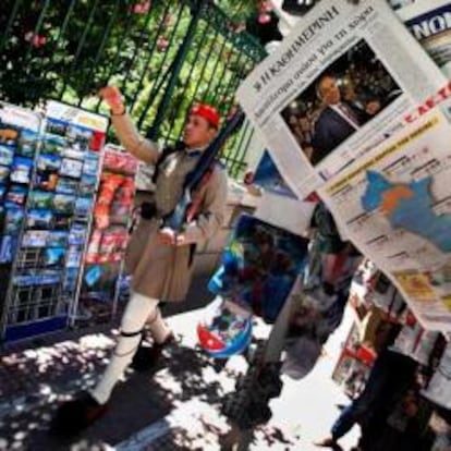 Un guardia presidencial pasa al lado de las portadas de los periódicos de Atenas el día después de las elecciones.