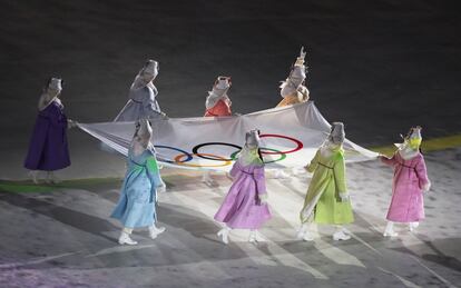 Voluntàries porten la bandera olímpica a l'estadi de Pyeongchang durant la cerimònia d'inauguració dels Jocs Olímpics d'Hivern 2018.