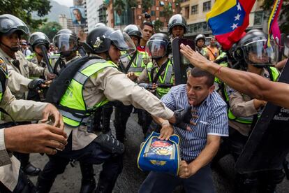 Agentes da Polícia Nacional Bolivariana cercam um manifestante na cidade de Caracas.