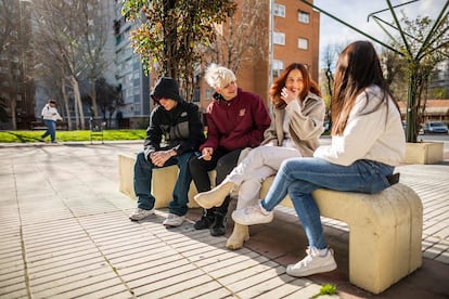 Unai (izquierda) sentado junto a Rubén, Nerea y Alejandra en una plaza de Fuenlabrada, en Madrid.