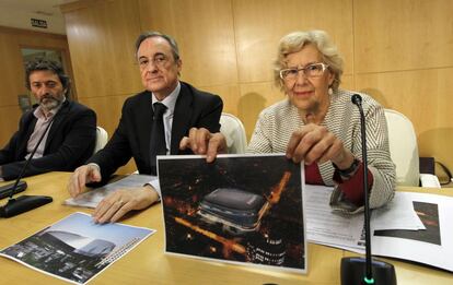 Manuela Carmena, alcaldesa de Madrid, sujeta una recreación del futuro Bernabéu en una rueda de prensa este martes. A su lado, Florentino Pérez, presidente del Real Madrid, y Mauricio Valiente, concejal del distrito de Chamartín.