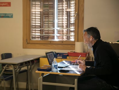 Un profesor de la escuela Pia Balmes de Barcelona da clase a sus alumnos confinados, a través del ordenador desde el aula.