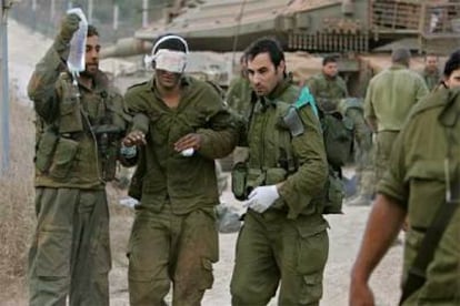 Un soldado israelí herido es evacuado por un grupo de militares en la frontera entre Israel y Líbano.