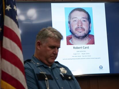 A police officer stands next to a screen displaying the picture of the suspected shooter, during a press conference following the deadly mass shooting, at City Hall in Lewiston, Maine, U.S. October 27, 2023.