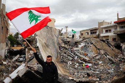 Un hombre ondea una bandera libanesa junto a los escombros de un edificio destruido por los ataques israelíes, este miércoles en Tyre, en el sur del Líbano. 