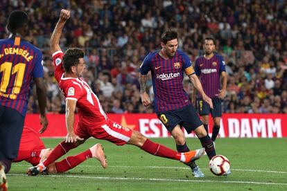 Lionel Messi evita la entrada de Pedro Alcala.