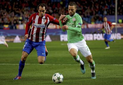 El centrocampista del PSV Eindhoven Bart Ramselaar (derecha) pelea por el balón con el uruguayo Diego Godín del Atlético de Madrid.