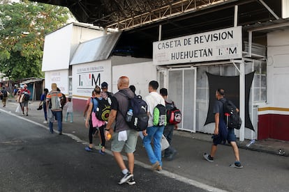 Migrantes caminan frente a una caseta de revisión del Instituto Nacional de Migración de Huehután. Los integrantes de la caravana han criticado las políticas migratorias mexicanas que provocaron la muerte de 40 migrantes en el incendio del centro de detención de Ciudad Juárez el mes pasado.