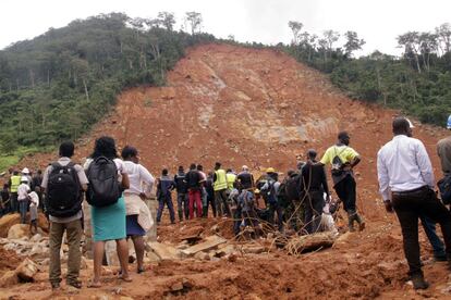 Voluntarios ante una colina en la que la semana pasada se produjo un corrimiento de tierras a causa de una tormenta, en Regent, a las afueras de Freetown, la capital de Sierra Leona. Los forenses han desenterrado al menos 499 cadáveres. Las fuertes lluvias hicieron que la ladera del Monte Sugar Loaf se desprendiera el pasado lunes, enterrando grandes áreas d ela ciudad de Regent e imposibilitando la asistencia en uno de los países más pobres del mundo.