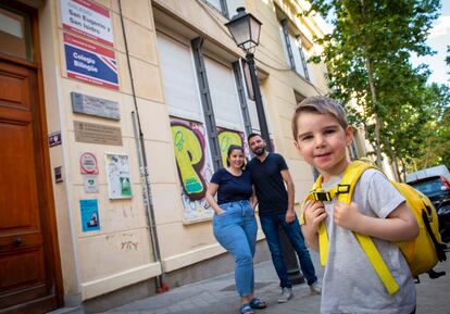 Óliver, con sus padres Araceli y Pedro, delante del colegio al que asistirá el próximo curso, en el barrio madrileño de Acacias.