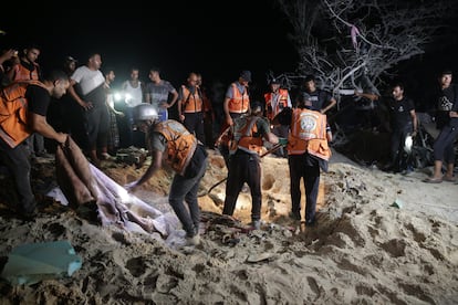 Operarios de los servicios de emergencia buscan bajo la arena víctimas del ataque israelí en el campamento de desplazados de Al Mawasi, cerca de Jan Yunis, en el sur de Gaza, este martes.