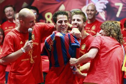 Reina, Piqué y Puyol ponen a Cesc una camiseta del Barça durante las celebraciones del Mundial.