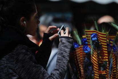 Una dona fa una fotografia a una rosa blava. 