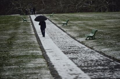 Un hombre sujeta su paraguas mientras nieva en Pamplona (España). 
