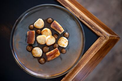 Plato de vieiras, papada y coliflor asada.