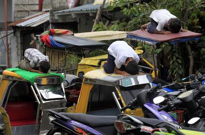 Jovens muçulmanos durante suas orações no topo de um mototáxi em frente à mesquita de Al-Satie na cidade Tondo (Manila), em 4 de julho de 2014.